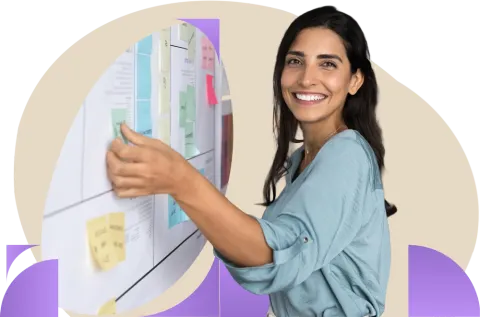 Person in blue shirt working on a kanban board with a happy expression