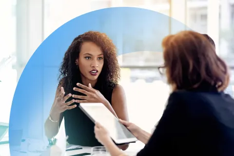 Colleagues in a professional discussion, with one holding a tablet