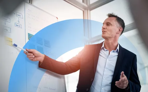 Business professional presenting ideas on a whiteboard during a meeting in a modern office.