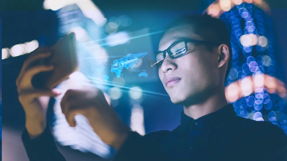 Person in glasses illuminated by blue neon lights checking smartwatch in dark setting