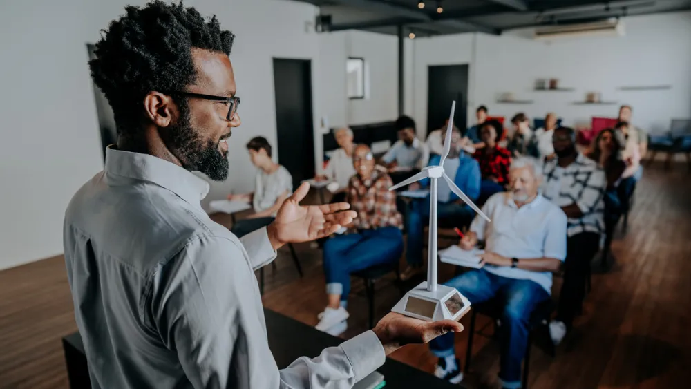 Speaker gesturing to engaged audience in bright modern classroom setting
