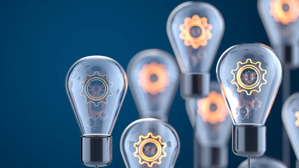 Multiple glowing lightbulbs with gear mechanisms inside against dark blue background