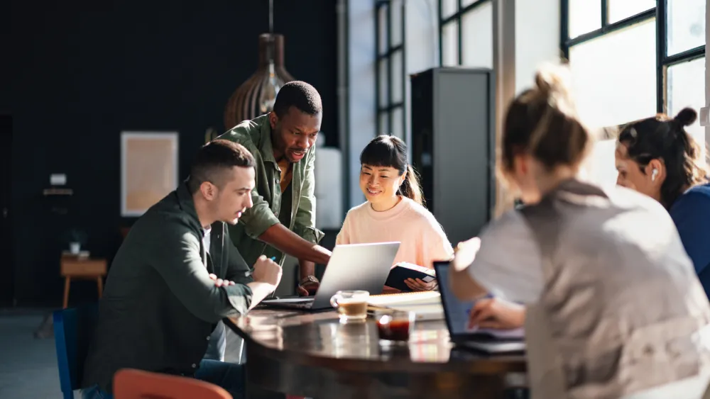 Groupe de personnes travaillant ensemble autour d'une table dans un bureau lumineux