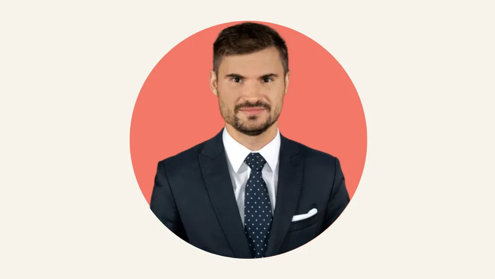 Hombre con traje oscuro y corbata azul sobre fondo rojo circular