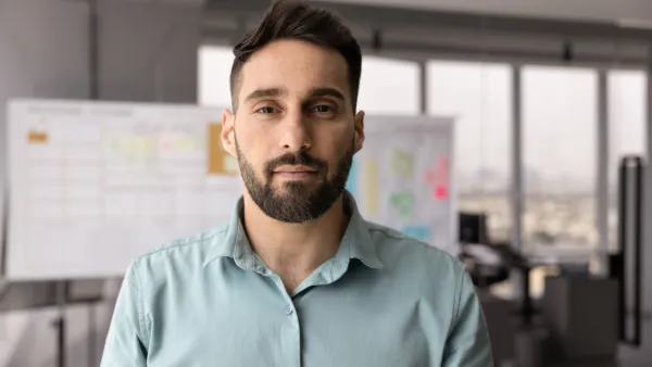 Man in an office with Kanban Board