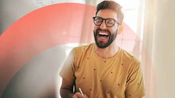 Smiling professional standing by a whiteboard, laughing and engaging during a creative brainstorming session.