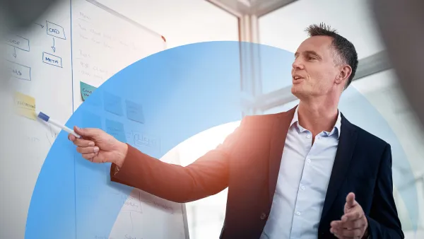 Business professional presenting ideas on a whiteboard during a meeting in a modern office.